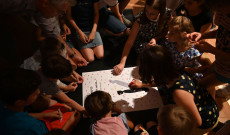 Matricákkal díszitik a plakátot a gyerekek