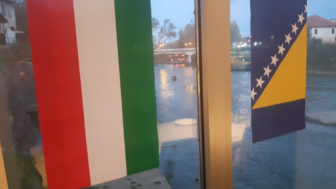 Magyarország és Bosznia-Hercegovina zászlaja, háttérben az Orbász folyó Magyarország és Bosznia-Hercegovina zászlaja, háttérben az Orbász folyó