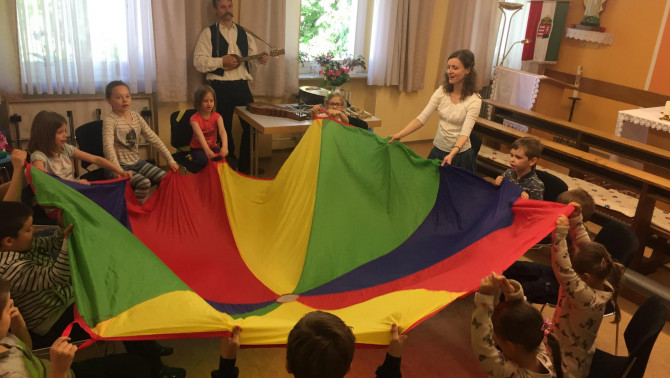 A szivárvány színű ejtőernyő "Kerekítő" foglalkozás az iskolában